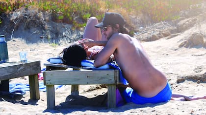 En la playa, toman mate, nadan en el mar y se sacan fotos.