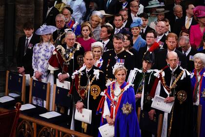 En la primera fila, el duque y la duquesa de Edimburgo, a la espera de la familia de William. En la segunda fila, James, duque de Wessex, lady Louise Windsor, los duques de Gloucester, el viceadmirante Sir Tim Laurence, la princesa real Ana y el príncipe Eduardo de Kent. En la tercera fila, el príncipe Andrés, la princesa Beatrice y su marido, Edoardo Mapelli Mozzi, la princesa Eugenia y su marido, Jack Brooksbank, el príncipe Harry y la princesa Alejandra de Kent, prima de la reina Isabel II.
