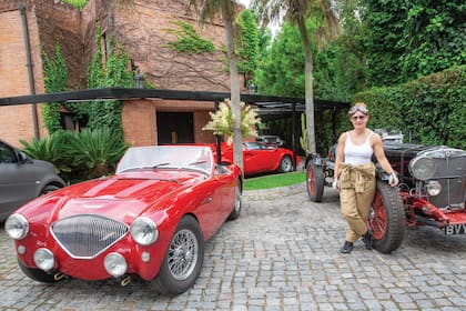 En la puerta de su casa, Margarita con dos de sus autos, un MG SA de 1936 y un Austin Healey 100 de 1956