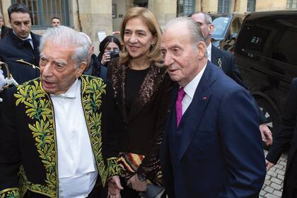 En la puerta del Instituto Francés, el rey emérito de España, Juan Carlos, y su hija, la infanta Cristina, saludan a Vargas Llosa.