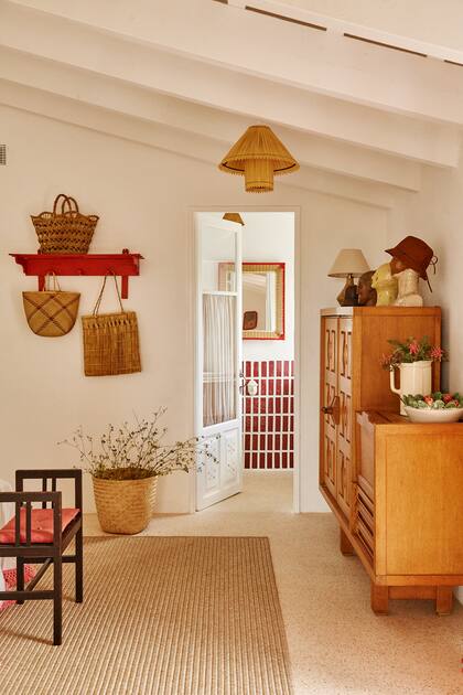 En la repisa, los tapizados y adornos se repite la paleta. El revestimiento del baño se colocó de modo vertical con un rojo dominante.