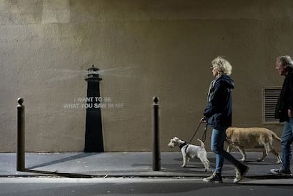En la segunda imagen que el graffitero compartió, una pareja pasea a sus perros frente a la nueva pintada