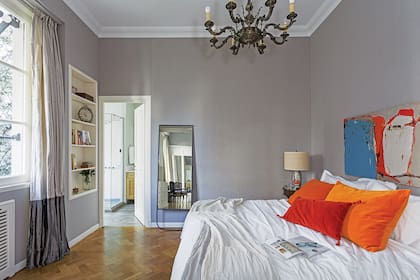 En la suite principal, una base neutra cede ante los almohadones de colores (Entredos) y el cuadro de Tatita Ganly. Edredón de pluma y pie de cama de gasa doble (Entredos).