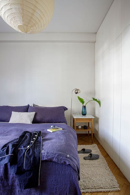 En la suite, una sencilla lámpara de papel de arroz y la cama vestida con un edredón de lino en azul profundo. Alfombra (Ilo argentino) y mesa de luz con tapa de mármol.