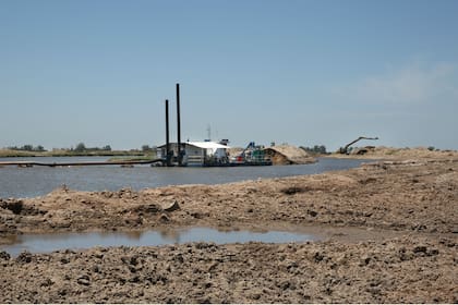 En las márgenes del río, el trabajo se complementa con retroexcavadoras