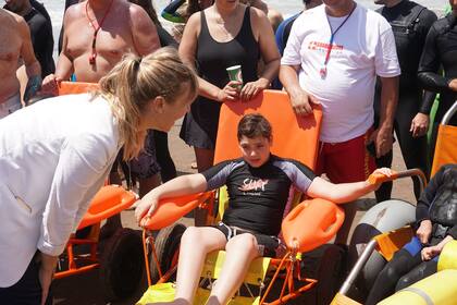 En las playas de la provincia de Buenos Aires, las sillas anfibias hacen posible que personas con discapacidad se puedan meter al mar