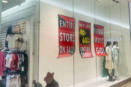 En las vidrieras de la tienda se pueden ver carteles con el mensaje “Everything must go” y anuncios de descuentos de hasta 60% (Christine Schuster)
