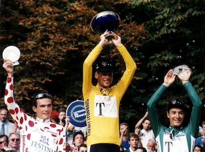 En lo más alto del podio de París, tras ganar el Tour de Francia de 1997, flanqueado por el francés Richard Virenque y el italiano Marco Pantani