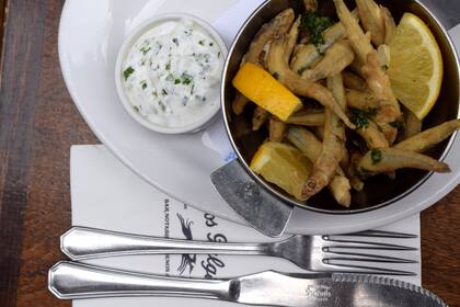 En Los Galgos los cornalitos se sirven en una cazuela con una rodaja de limón y una emulsión de provenzal (ajo y perejil).