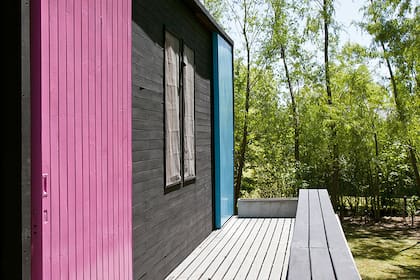 En lugar de tener una baranda, el deck sube y se transforma en un largo banco para sentarse a mirar el bosque