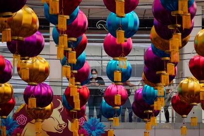 En Manila, Filipinas, una mujer toma una foto de los faroles chinos que se colgaron en un área pública como parte de las celebraciones suprimidas del Año Nuevo chino