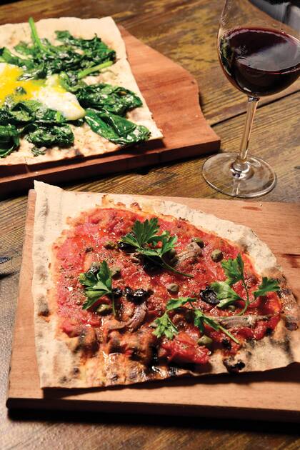 En Mil y Pico la masa, fina y ligera, se cocina en una parrilla que arde con madera de quebracho