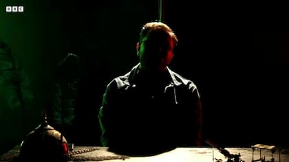 En nuestra videollamada con el Sr. Explosive, él aparece en sombras y flanqueado por luces rojas y verdes.