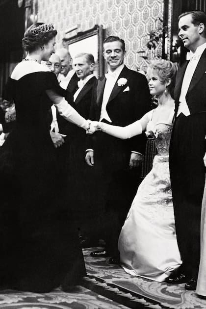 En octubre de 1956, durante un acto oficial en Londres, se inclina frente a la reina Isabel II