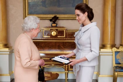 En octubre de 2014, la actriz Angelina Jolie recibe de manos de Isabel II el título de dama honoraria de la Distinguidísima Orden de San Miguel y San Jorge por su campaña para poner fin a la violencia sexual en zonas de guerra.
