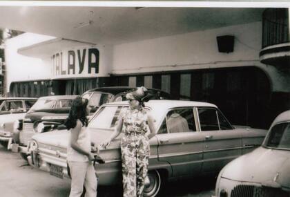 En otra imagen de la década del "boom" económico de la Argentina, dos mujeres conversan en la playa de estacionamiento