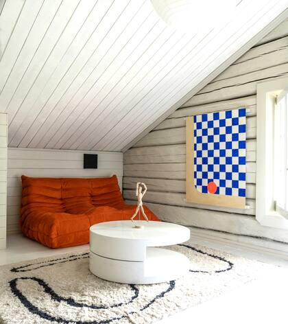 En otro rincón de la casa de Nicole Castillo, el famoso sillón 'Togo', un modelo original de la firma francesa Ligne Roset, en naranja.