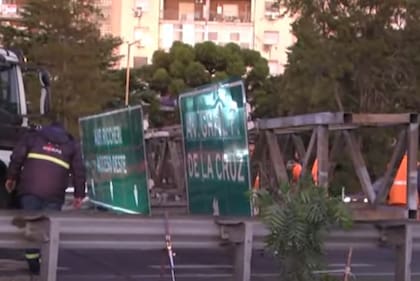 En plena hora pico, técnicos de la concesionaria Ausol trabajaban en el lugar para intentar remover el cartel, ya que uno de sus extremos quedó colgado y corre peligro de derrumbe.