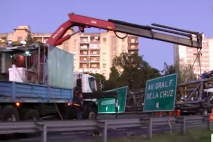 En plena hora pico, técnicos de la concesionaria Ausol trabajaban en el lugar para intentar remover el cartel, ya que uno de sus extremos quedó colgado y corre peligro de derrumbe.