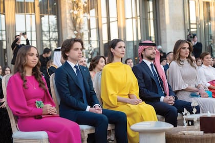 En primera fila estaban, de izquierda a derecha, la princesa Salma (llevó un vestido de Andrew Gn), el príncipe Hashem, el príncipe Hussein con su prometida, la arquitecta saudí Rajwa al-Saif (impactó con un vestido-capa de Roksanda) y la reina Rania.