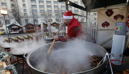 En Rumania, este Papá Noel se quitó la barba y decidió cocinar una gran cena en una feria local