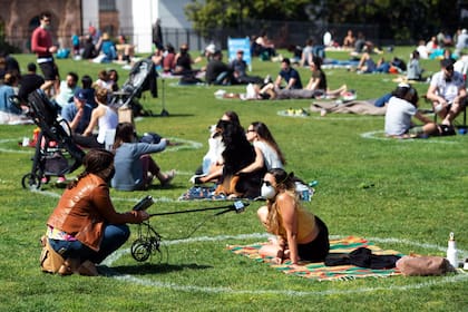 Una mujer es entrevistada desde el interior de un círculo pintado en la hierba en el Dolores Park en San Francisco, Estados Unidos