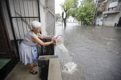 En San Justo los vecinos tratan de desagotar el agua de sus viviendas con baldes luego de la fuerte lluvia de ayer