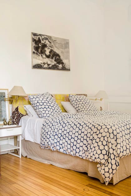 En su cama, un textil de origen africano se combinó con un respaldo tapizado con un género de Anthropologie. Encima un cuadro de Tomás Espina, colega y amigo.