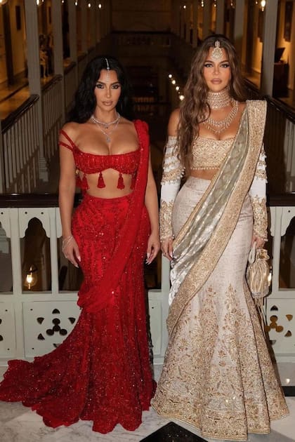 En su
primera aparición, Khloé
Kardashian, quien posa con su hermana Kim, lució un sari
en blanco y oro con joyas
tradicionales sobre la
frente, un collar dorado y
una gargantilla de varias
vueltas.