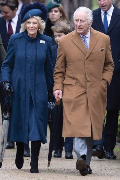 En su primera misa navideña como soberano, Carlos III camina muy sonriente junto a la reina consorte, Camilla. 