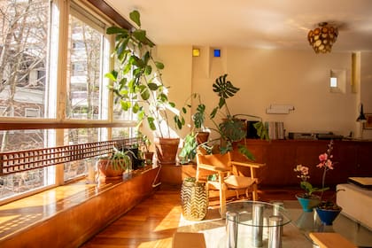 En su primera parte, el mueble que recorre el departamento ofrece espacio de guardado; en su continuación, actúa como banco y lugar de apoyo.