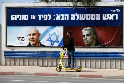En Tel Aviv, los afiches electorales de Netanyahu incluyen una foto de su rival Lapid, con el rostro serio, que contrasta con la sonrisa del primer ministro y la bandera israelí de fondo.