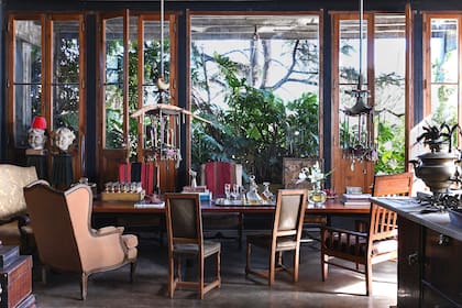 En torno a la mesa hecha con un gigantesco bloque de madera, un Bergère heredado, el par de sillas que quedó en la propiedad de la esquina (incorporada en una ampliación) y el sillón de madera que vino de su casa natal.