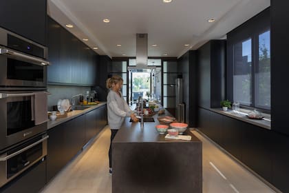 En un ambiente rectangular, la isla y las mesadas de Neolith ‘Beton’ mate (De Stefano) generan un espacio cómodo y generoso, tan atractivo para cocinar como para extender la charla hasta que llegue el momento de sentarse a la mesa.