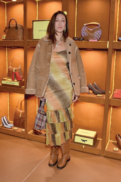 En un evento en California, la modelo posó para los fotógrafos con un look bohemio: vestido con volados, gamulán, botas y bolso estampado.