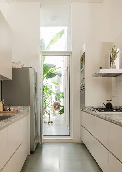 En un extremo de la cocina, grandes transparencias comunican con un patio con piso de terrazzo (Quadri).