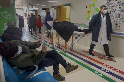 En un hospital de Pekín, un hombre es trasladado en camilla mientras crecen los casos de Covid por los contagios en las celebraciones de Año Nuevo