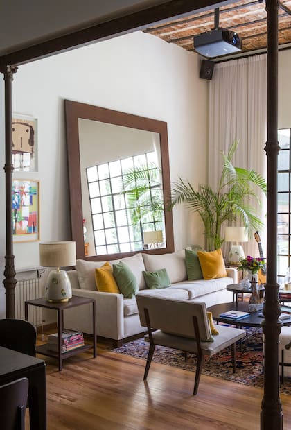 En un reciente trabajo de interiorismo de Salazar Estudio, un inmenso espejo con marco de chapa acompaña el sofá en pana, lámparas ‘Bicho’ y mesas bajas con base de hierro (todo de Salazar Casa).