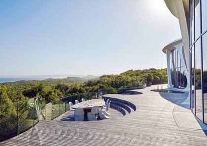 En un recorte del deck, la mesa diseñada por Rech junto a las sillas ‘Panton’.