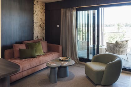 En un rincón del living del "Departamento 203", sillón diseñado a pedido de Halesa por Thais, alfombra de RugIt, cortinas de Hunter Douglas y revestimiento de pared de Patagonia Flooring combinado con piedra de De Stefano.