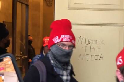 En un video tuiteado por Matthew Miller que circuló ampliamente en las redes sociales, el grafiti “Muerte a los medios” se muestran en una puerta del Capitolio de Estados Unidos cuando los insurrectos abandonan el edificio el 6 de enero de 2021