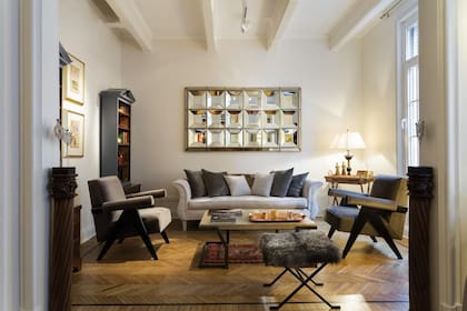 En una ambientación reciente, equilibrado juego de textiles en un living dominado por un espejo op art.