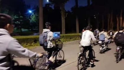 En una de las fotos, un estudiante de la Universidad Tsinghua utilizaba su computador portátil mientras montaba en bicicleta