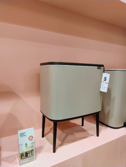 En verde seco, de forma alargada y con patas delgadas, un tacho para la basura que no es feo de ver, por fin