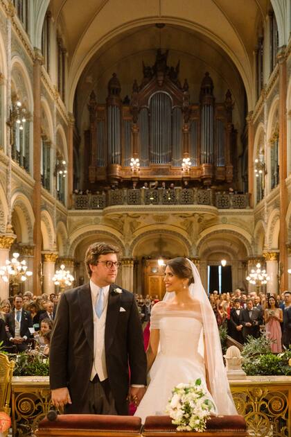 Enamoradísimos, Georgie y Taina se miran y se preparan para uno de los momentos especiales de la ceremonia en el Santísimo Sacramento: el intercambio de los anillos.