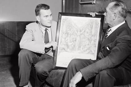 Enero de
1956. John B. le muestra a su hijo el premio olímpico de
remo que ganó en París, en 1924.