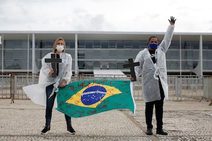 Enfermeras protestan contra el presidente brasileño Jair Bolsonaro y rinden homenaje a los trabajadores de la salud que murieron por complicaciones del nuevo coronavirus durante una manifestación frente al Palacio Planalto, en Brasilia, el 1 de mayo de 2021