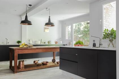 Enfrentadas, filas de muebles (Johnson Acero) con tapa de Silestone ‘White Storm’. Lámparas galponeras (Iluminación Agüero).