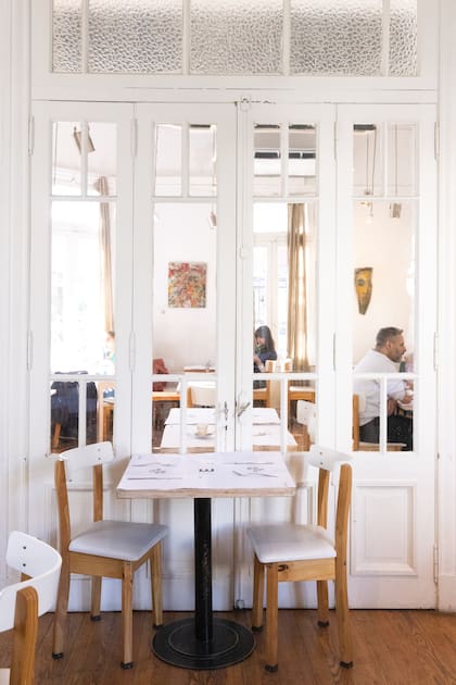 Enfrente funciona en una propiedad antigua con varios salones de techos altos, pisos de madera y molduras originales