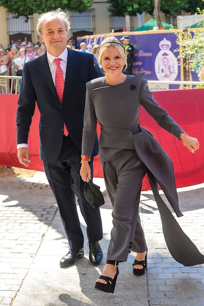 Enfundada en un conjunto de dos piezas -chaqueta de líneas asimétricas con cruce lateral y pantalón al tobillo, y, además, un tocado de red–, firmado por el diseñador gallego Roberto Diz, Eugenia Martínez de Irujo, duquesa de Montoro y hermana del novio, llega la iglesia acompañada por su marido, el empresario musical Narcís Rebollo